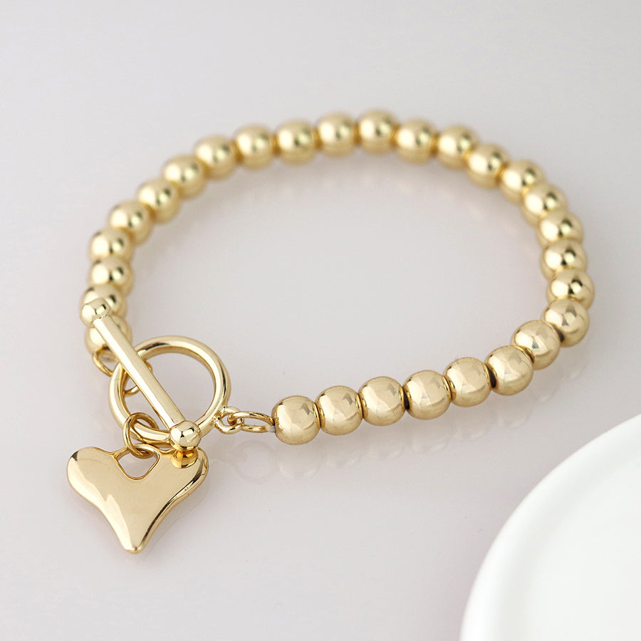 Golden bead and heart charm tbar bracelet